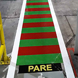 senda peatonal con señas de pare pintadas en el piso antes de cruces peligrosos dentro de fabrica